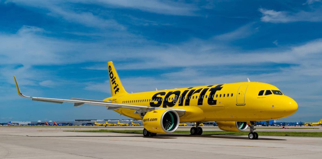 A bright yellow Spirit Airlines airplane on the runway