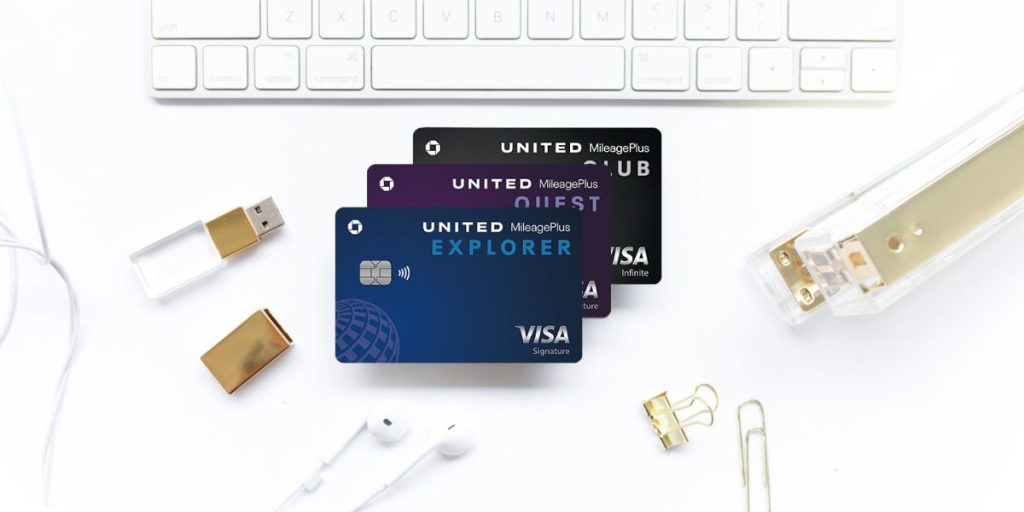 United credit cards with an apple keyboard, stapler, and USB drive.