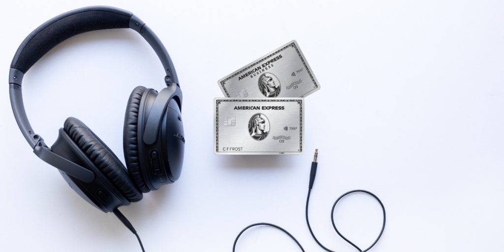 American Express Platinum and Business Platinum cards with a pair of headphones on a white background