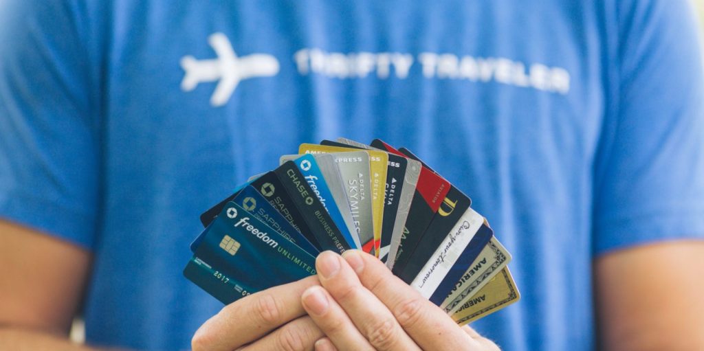 Man in Thrifty Traveler t-shirt holding credit cards